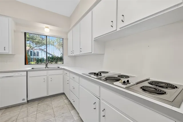 a kitchen with granite countertop white cabinets and white appliances