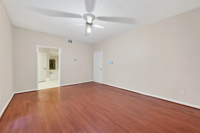 a spacious bathroom with a granite countertop double vanity sink a mirror and a bathtub