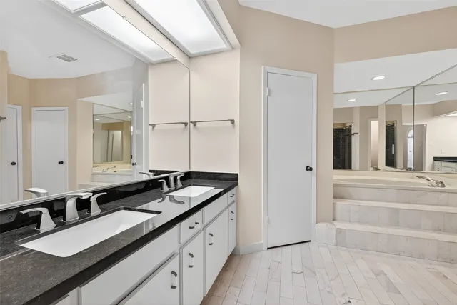 a bathroom with a tub shower and sink