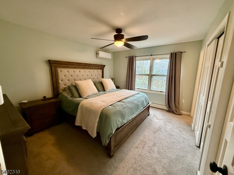 117 Papscoe Road West Milford, NJ 07421 - Photo 14 of 29 a bedroom with a bed and a chandelier