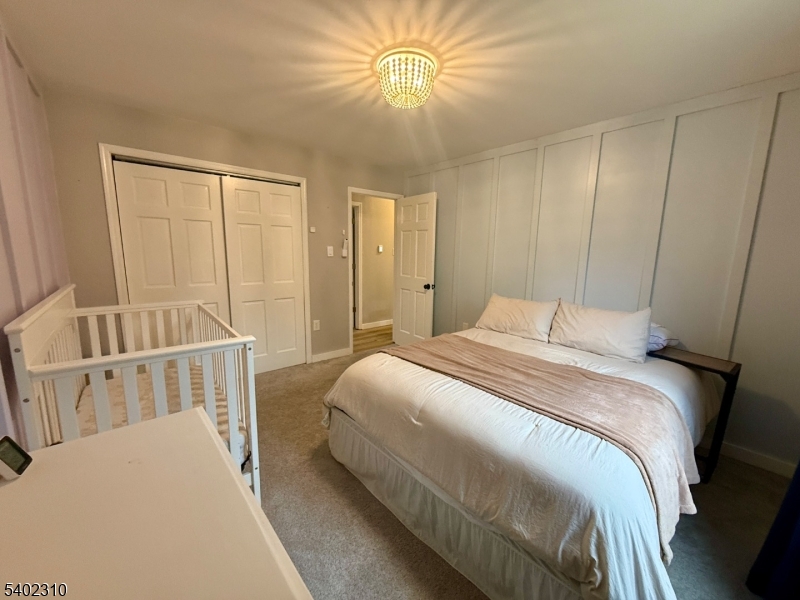 117 Papscoe Road West Milford, NJ 07421 - Photo 18 of 29 a bedroom with a bed and a chandelier