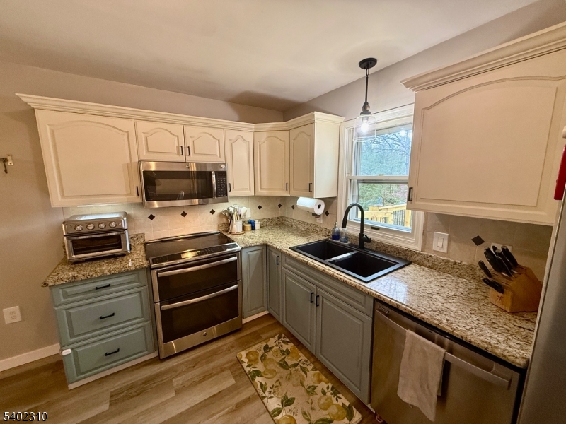 117 Papscoe Road West Milford, NJ 07421 - Photo 5 of 29 a kitchen with granite countertop a sink appliances and cabinets