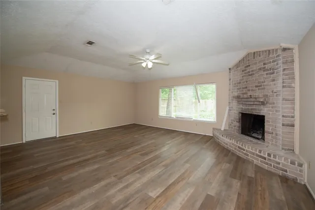 an empty room with windows fireplace and a sink