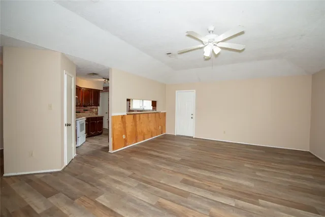 a view of a kitchen with wooden floor and a ceiling fan