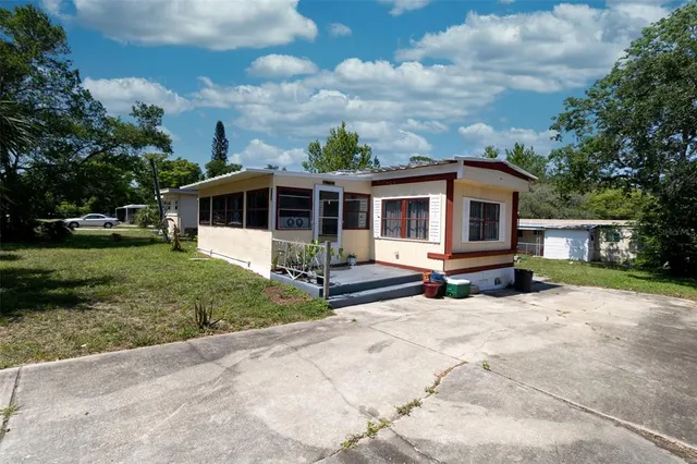 a view of a house with backyard and sitting area