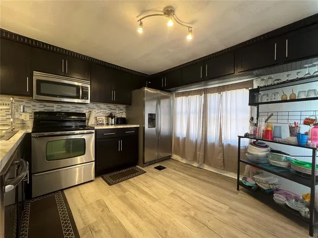 a kitchen with stainless steel appliances kitchen island granite countertop a stove and a sink