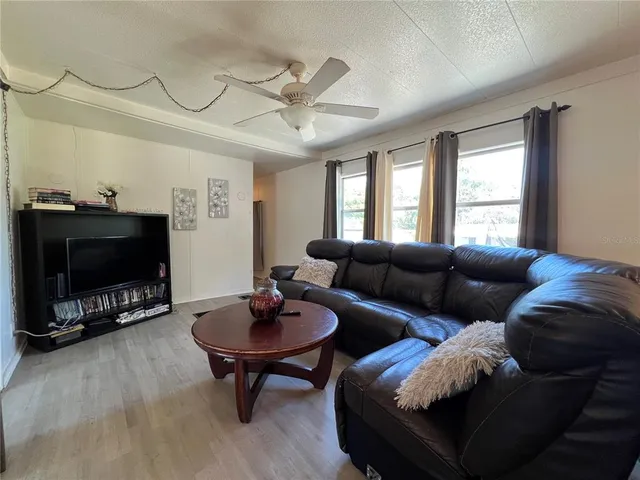 a living room with furniture a flat screen tv and a window