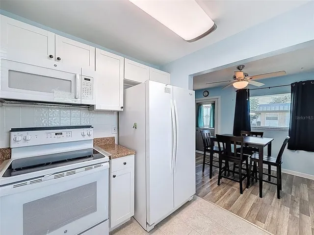 a kitchen with stainless steel appliances a stove a table and chairs