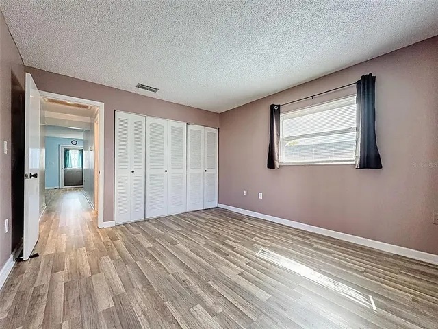 a view of a room with wooden floor and a window