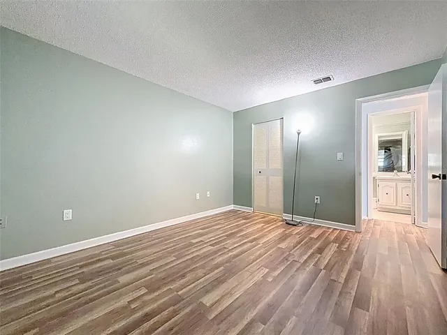 a view of a big room with wooden floor and a bathroom