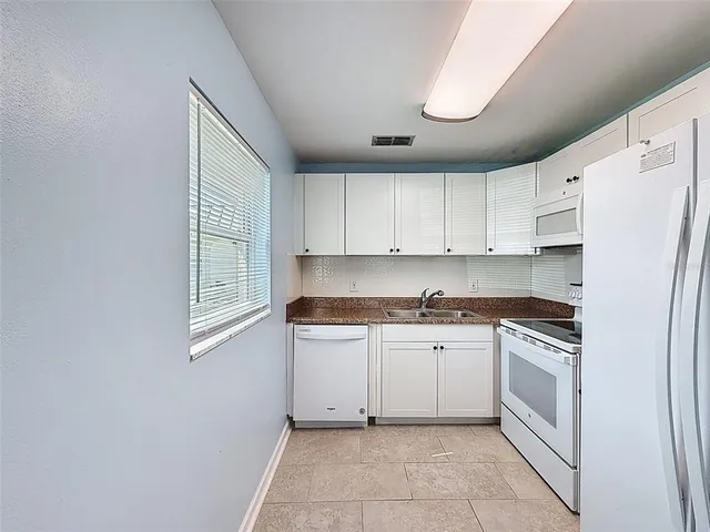 a kitchen with white cabinets and white appliances