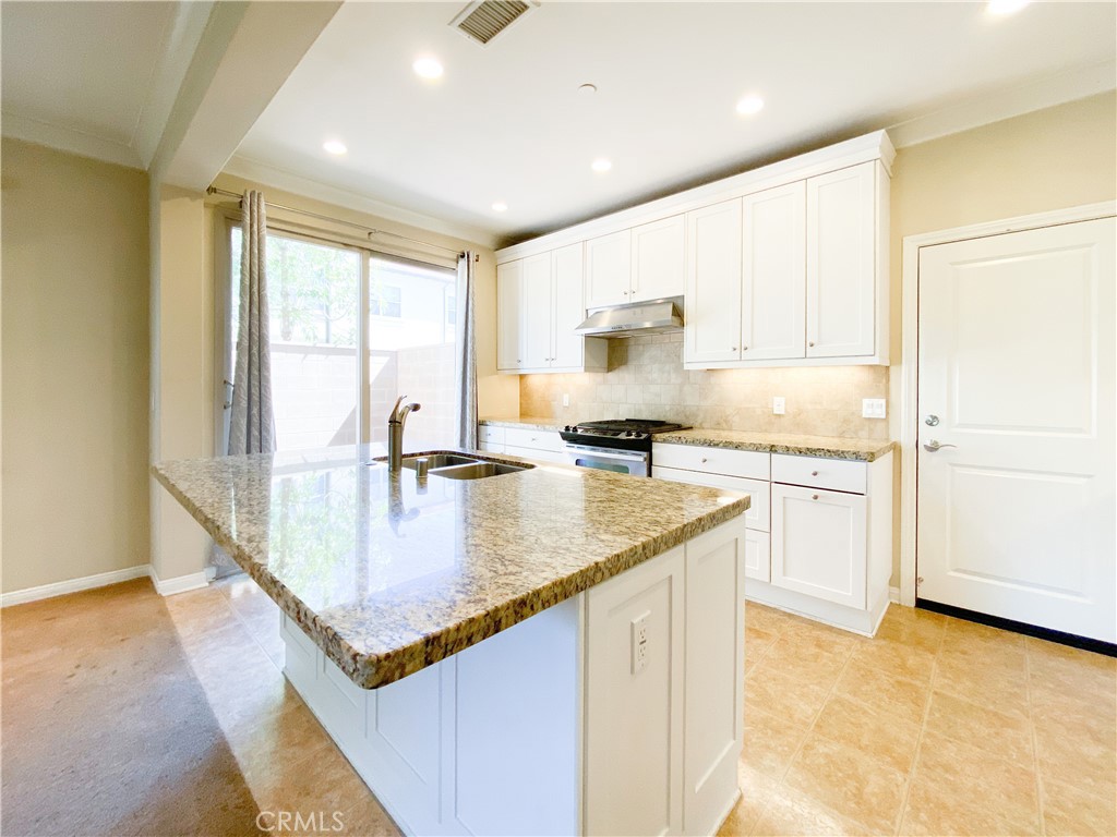 131 Thornhurst Irvine, CA 92620 - Photo 7 of 15 a kitchen with stainless steel appliances granite countertop a sink a stove and a refrigerator