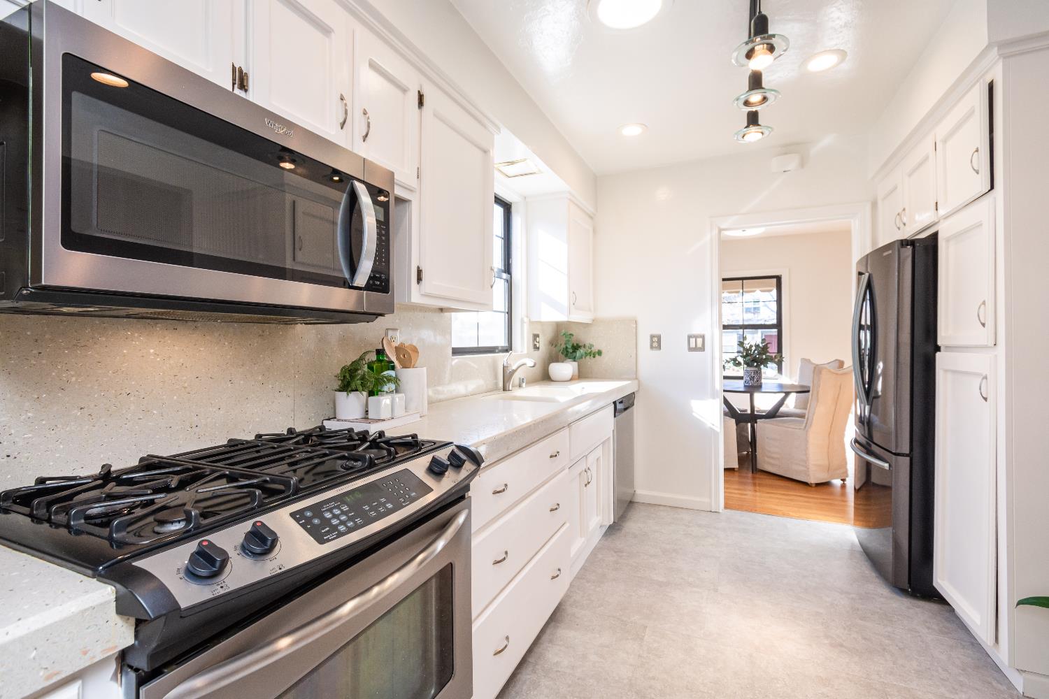151 Coloma Way Sacramento, CA 95819 - Photo 10 of 28 a kitchen with stainless steel appliances a stove a microwave cabinets and a counter top space