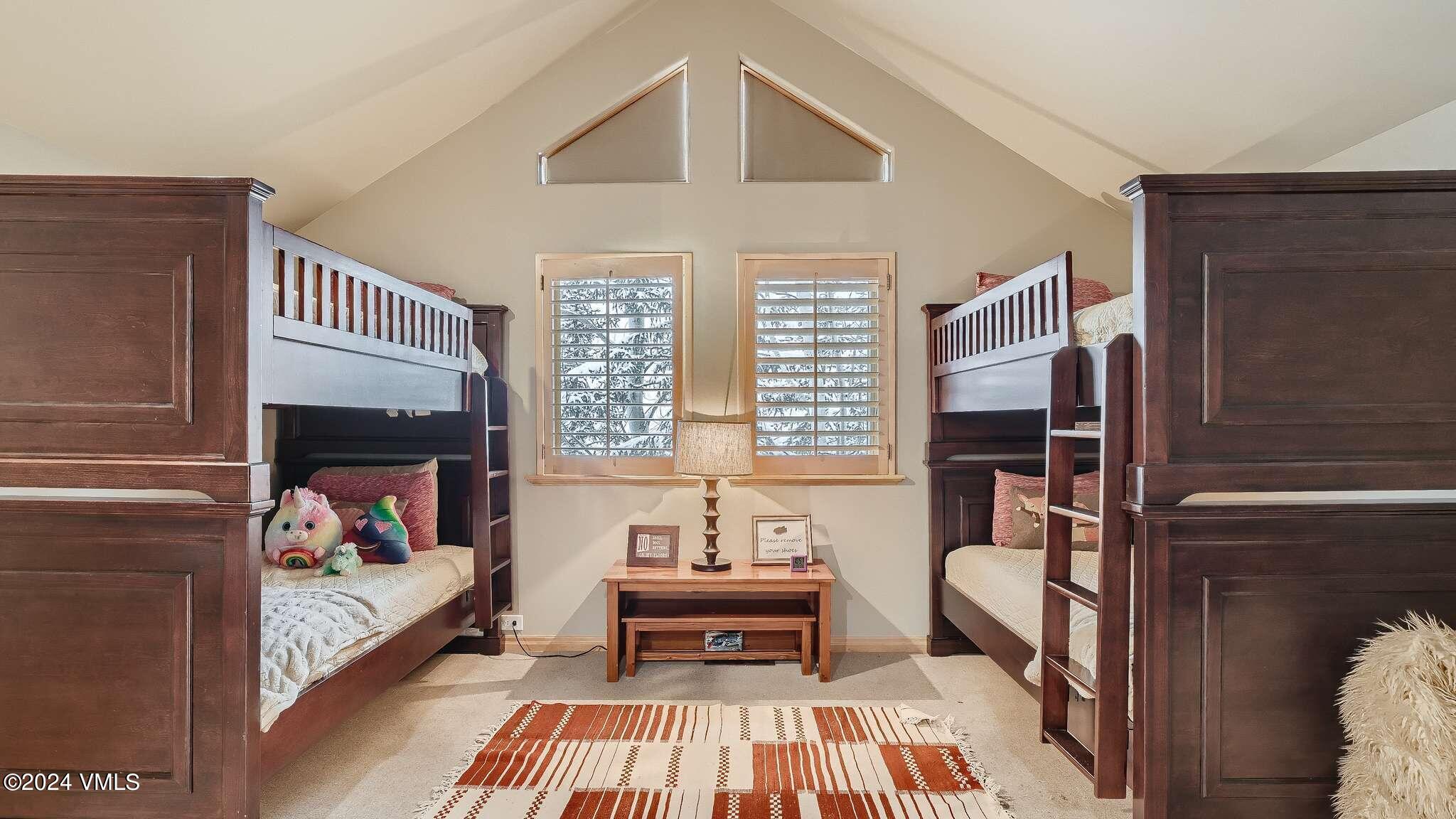 1675 Aspen Ridge Road Vail, CO 81657 - Photo 32 of 53 a bedroom with a bed and a chandelier