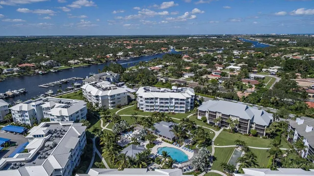 a living room with furniture floor to ceiling window and a flat screen tv