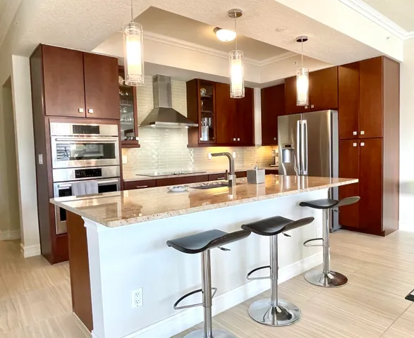 a kitchen with stainless steel appliances granite countertop a sink refrigerator and cabinets
