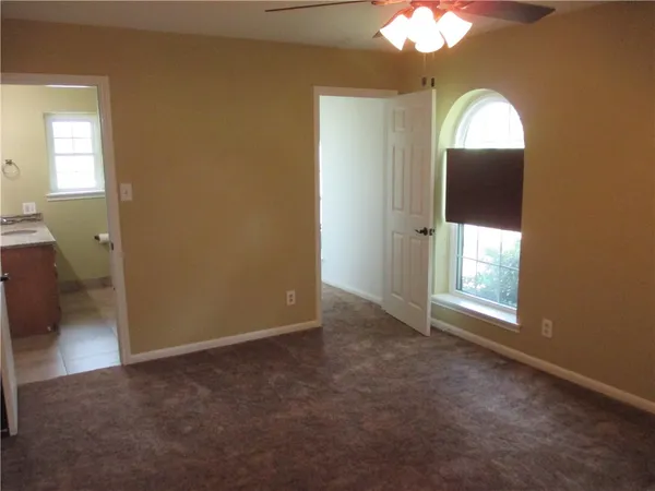 an empty room with a bathroom and a window