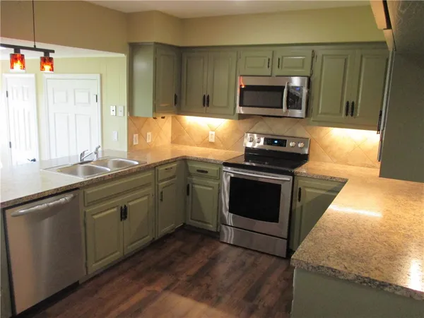 a kitchen with granite countertop a stove and a sink