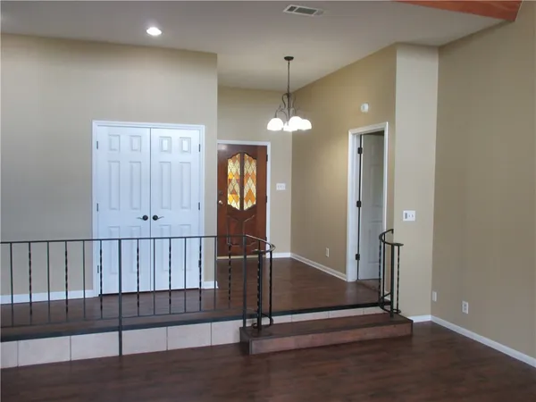 an empty room with wooden floor mirror and windows