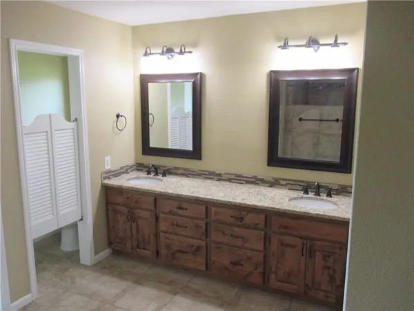 a bathroom with a double vanity sink and a mirror