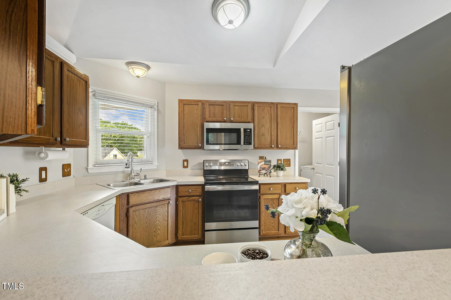 2105 Cardhu Way Raleigh, NC 27603 - Photo 3 of 9 a kitchen with stainless steel appliances granite countertop a sink stove and microwave