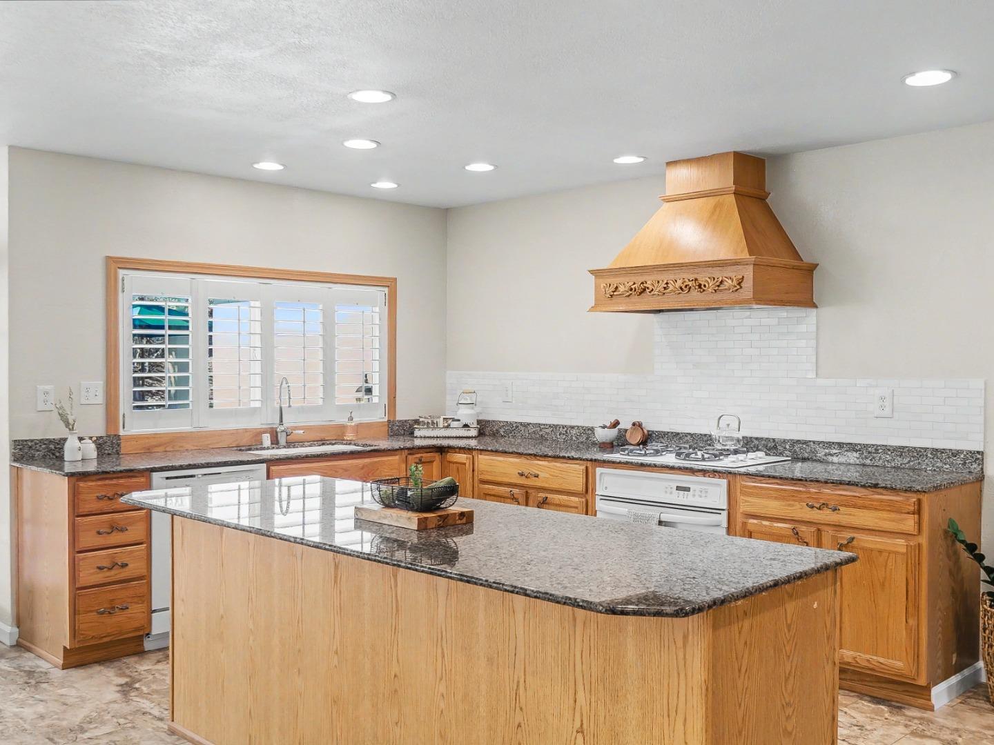 6455 Kensington Place Gilroy, CA 95020 - Photo 11 of 32 a kitchen with stainless steel appliances granite countertop a sink a counter space and a window