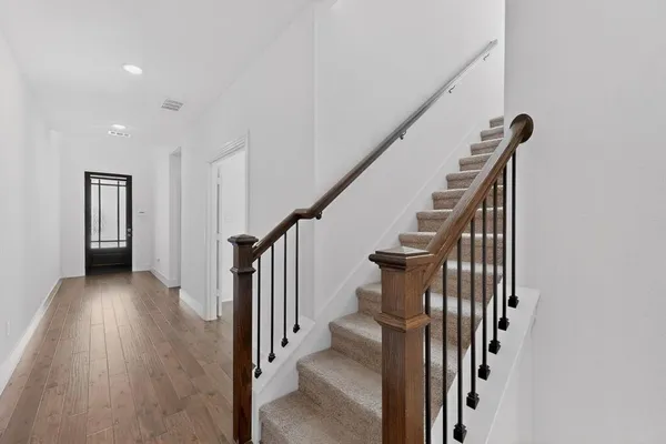 a view of a hallway with wooden floor and entryway