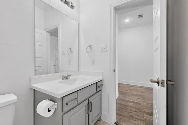 a bathroom with a sink a toilet and a mirror