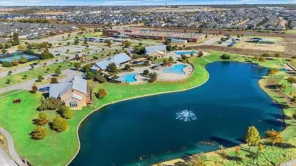 an aerial view of a house with a swimming pool yard and lake view in back