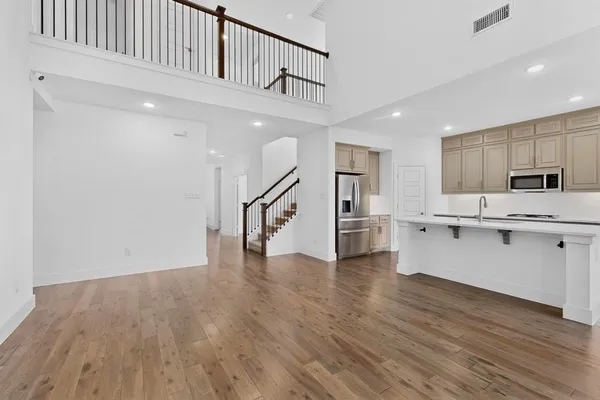 a view of a kitchen with wooden floor and electronic appliances