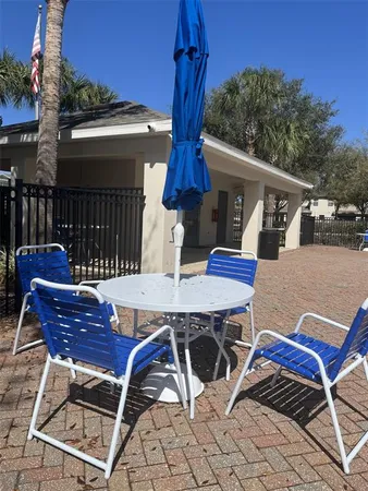 a view of a patio with table and chairs with wooden floor and fence