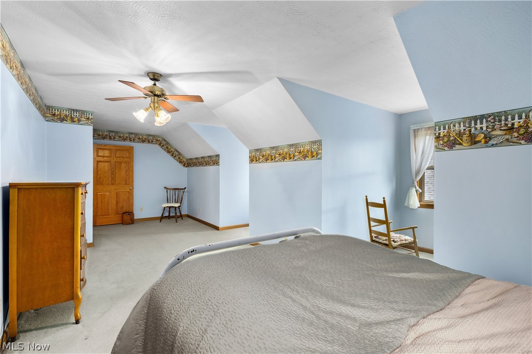 10909 Ruby Road Cambridge, OH 43725 - Photo 27 of 34 Bedroom with carpet floors, lofted ceiling, ceiling fan, and a textured ceiling