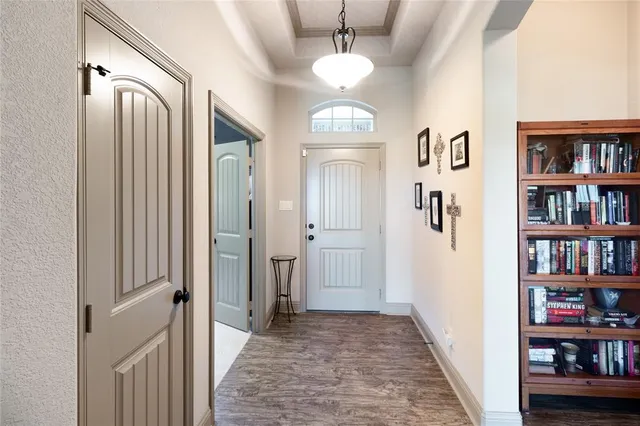 a view of a hallway with wooden floor and a bookshelf