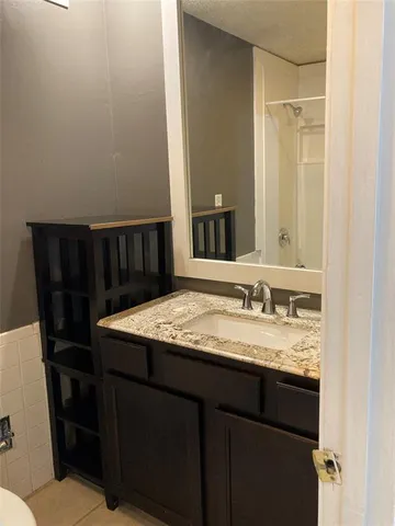 a bathroom with a granite countertop sink a mirror and a toilet