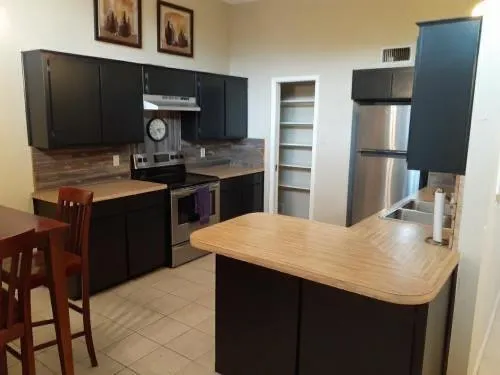 a kitchen with a sink refrigerator and cabinets