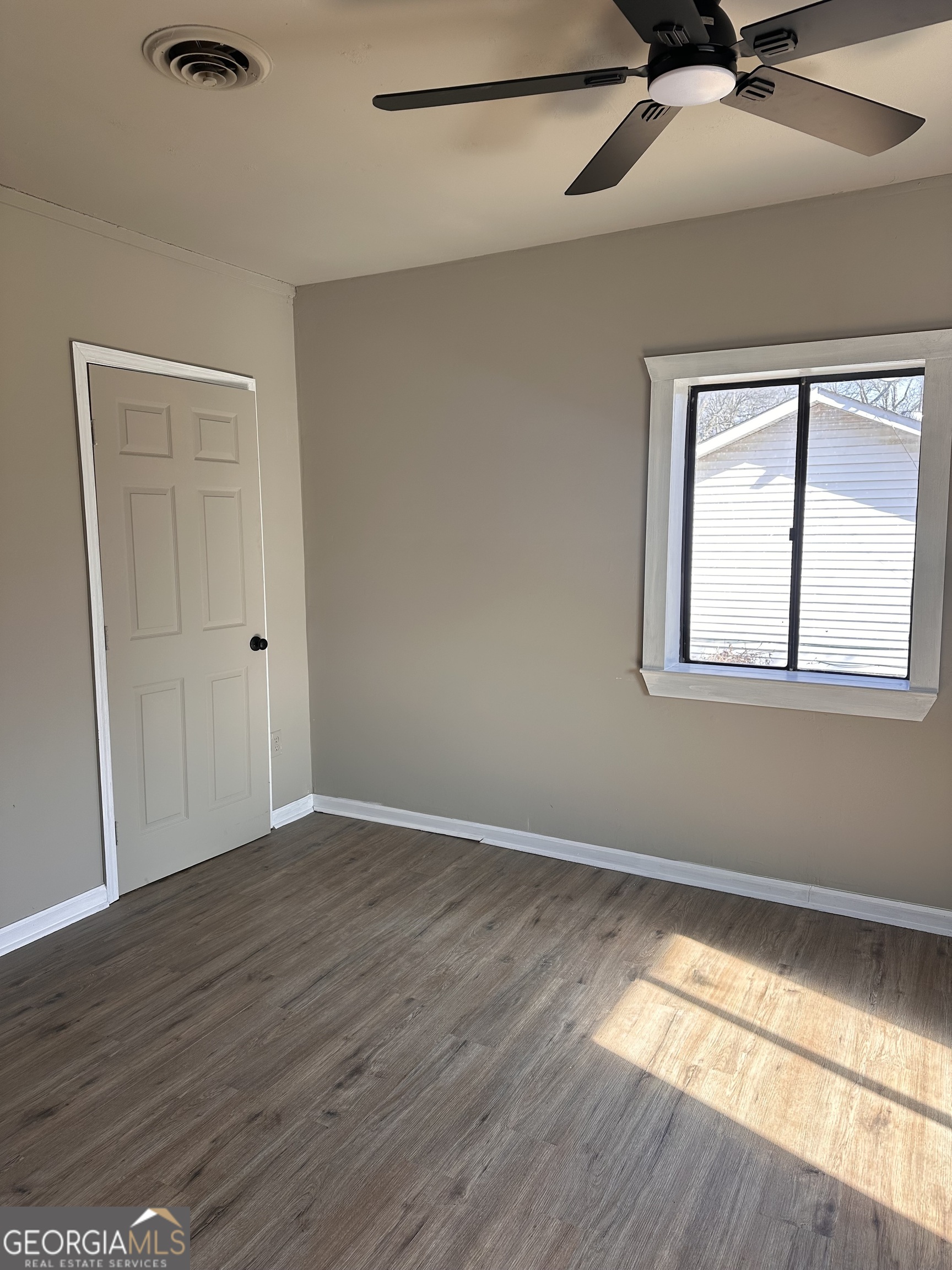 481 Main Street Clermont, GA 30527 - Photo 16 of 43 a view of an empty room with wooden floor and a window