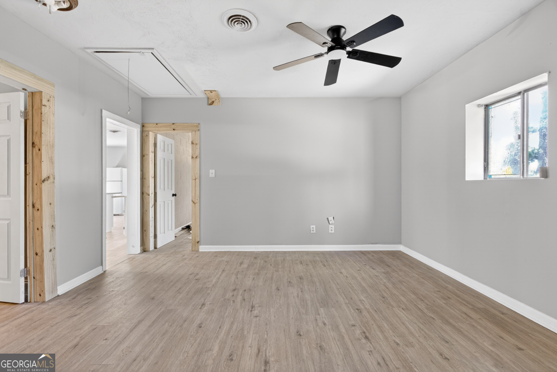 481 Main Street Clermont, GA 30527 - Photo 19 of 43 a view of a room with wooden floor and a ceiling fan
