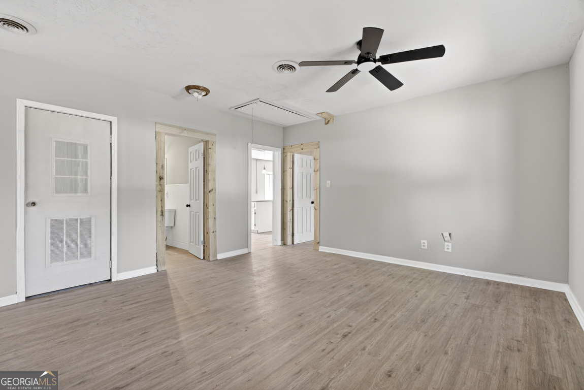 481 Main Street Clermont, GA 30527 - Photo 21 of 43 a view of a room with wooden floor and a ceiling fan