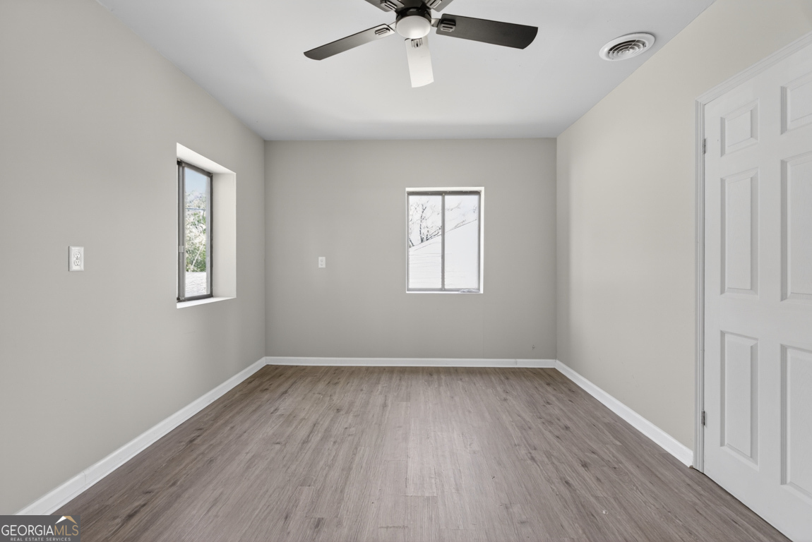 481 Main Street Clermont, GA 30527 - Photo 25 of 43 a view of an empty room with wooden floor and a window