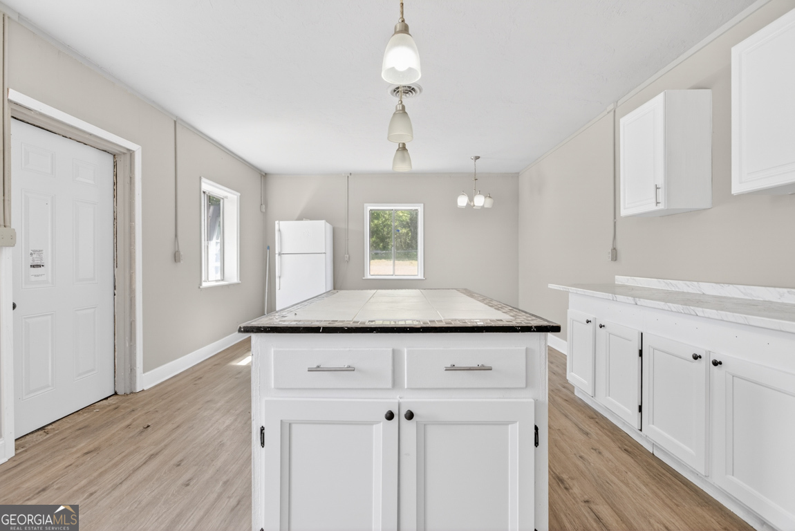 481 Main Street Clermont, GA 30527 - Photo 36 of 43 a kitchen with a granite countertop cabinets and wooden floor