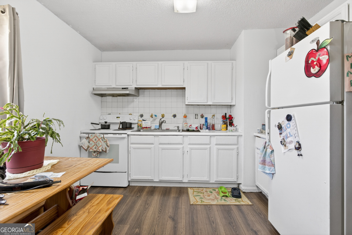 481 Main Street Clermont, GA 30527 - Photo 42 of 43 a white kitchen with a refrigerator and a white cabinets