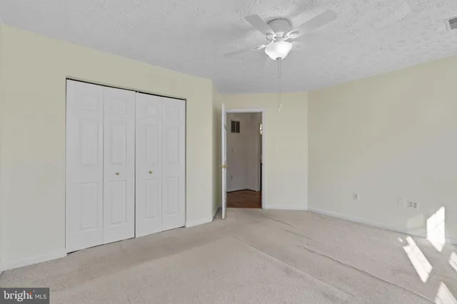 a bedroom with a large bed couch and windows