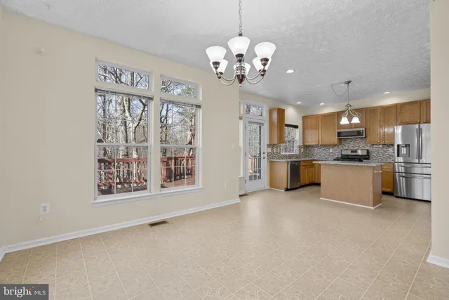 a view of a kitchen with a sink and dishwasher a refrigerator with white cabinets