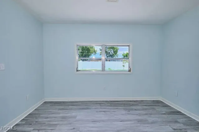 a view of a room that has wooden floor and window