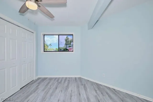 an empty room with a window and wooden floor