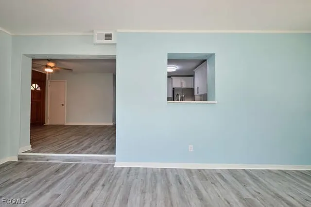 an empty room with wooden floor and mirror