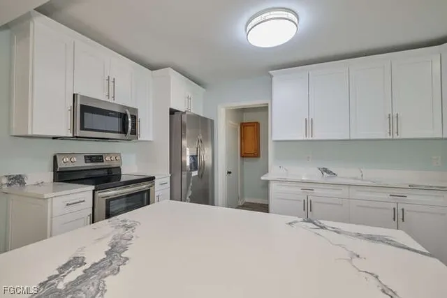 a kitchen with stainless steel appliances granite countertop a refrigerator stove microwave and sink