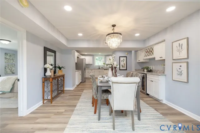 a view of a dining room with furniture a kitchen and chandelier