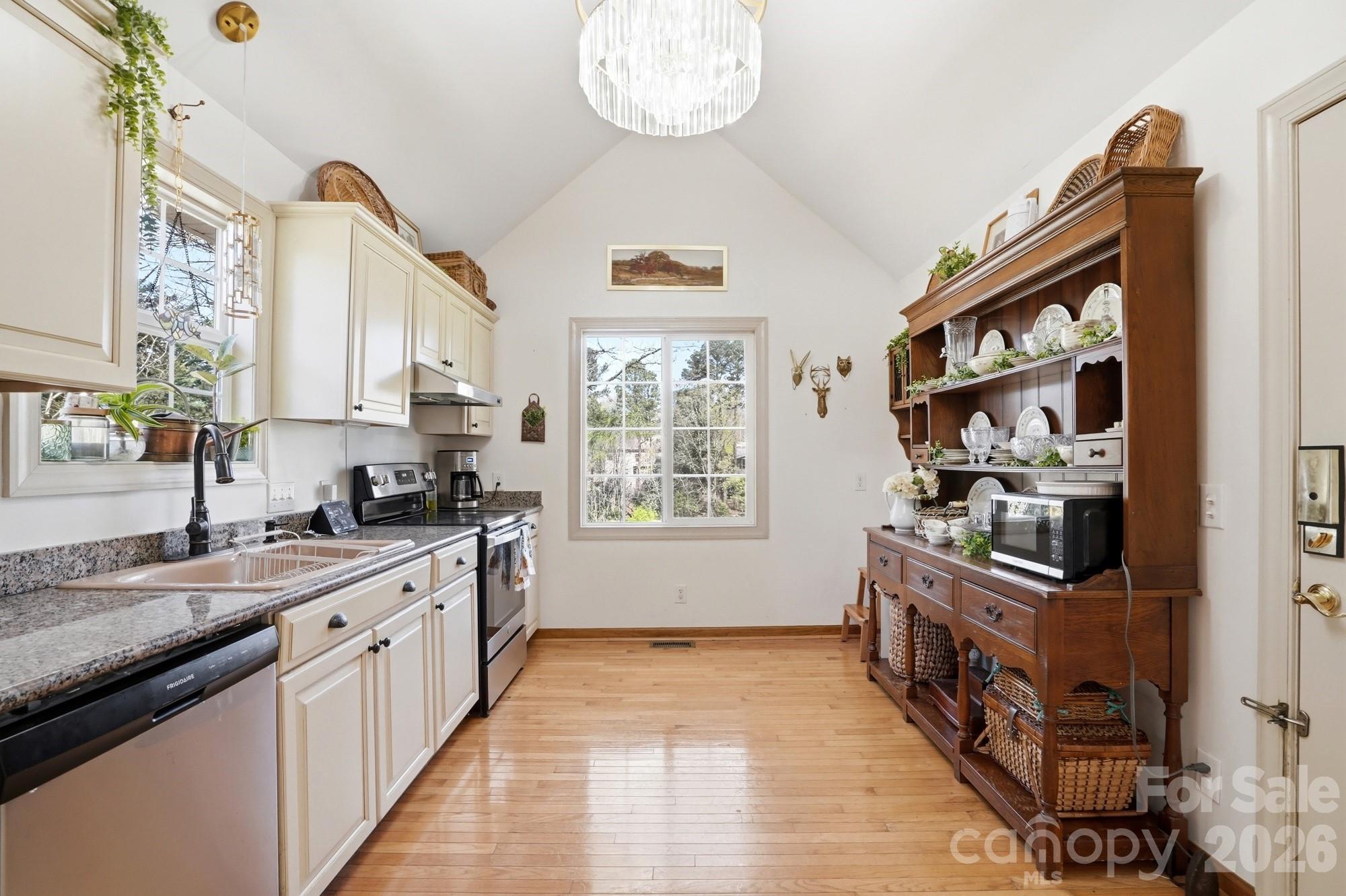 6046 Windjammer Drive Tega Cay, SC 29708 - Photo 16 of 46 a kitchen with stainless steel appliances a stove a sink and a refrigerator