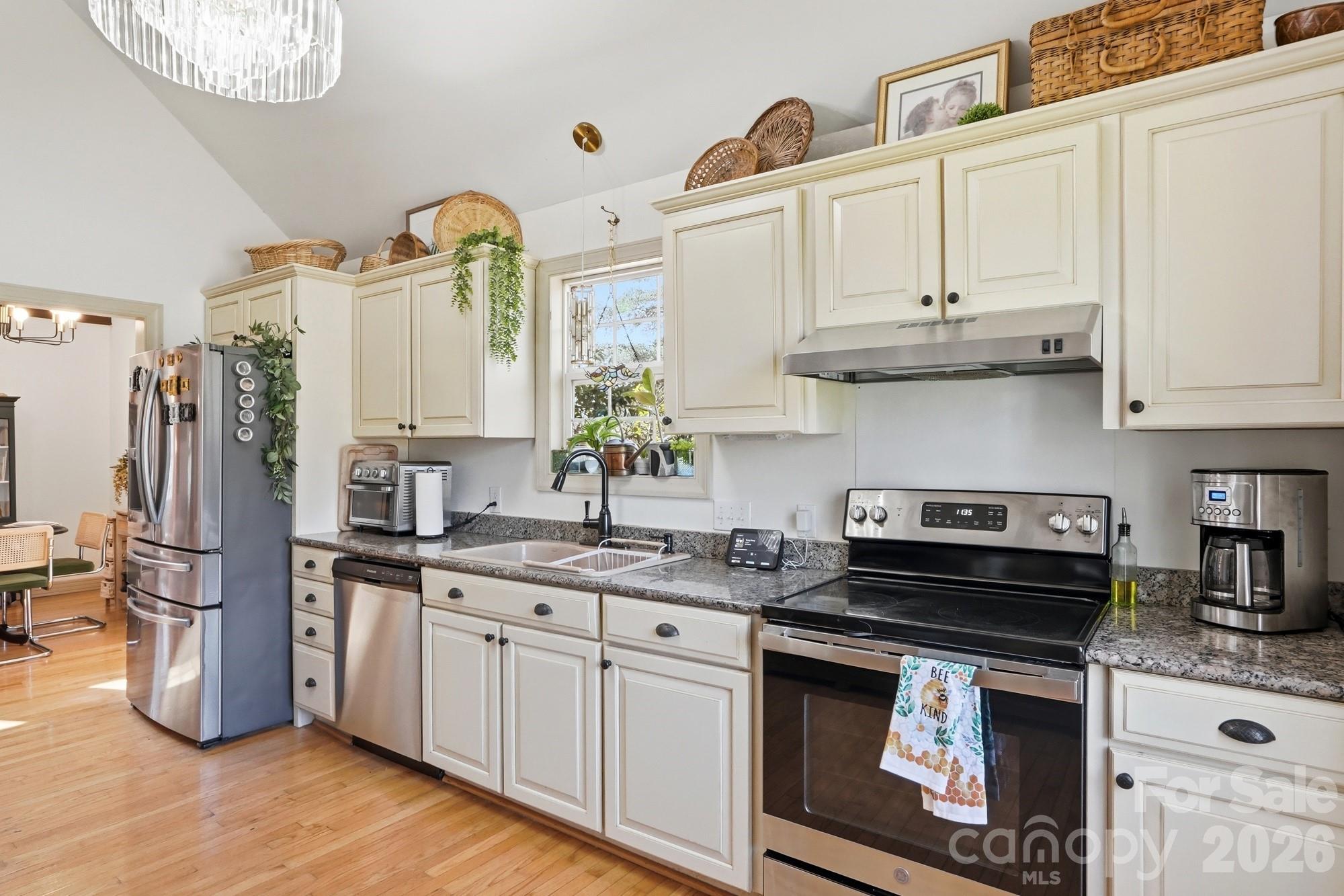 6046 Windjammer Drive Tega Cay, SC 29708 - Photo 19 of 46 a kitchen with stainless steel appliances granite countertop a stove a sink and white cabinets